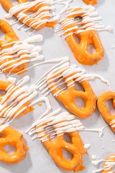 Drizzling melted chocolate over chocolate-dipped pretzels twists.