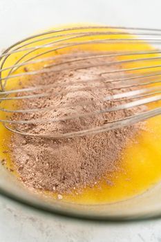 Mixing ingredients in a glass mixing bowl to bake s'mores cupcakes.