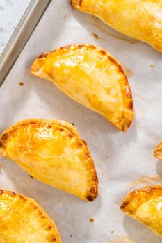 Freshly baked breakfast empanadas with eggs and sweet potato on the kitchen counter.