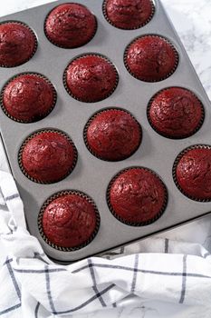 Cooling freshly baked red velvet cupcakes on a kitchen counter.