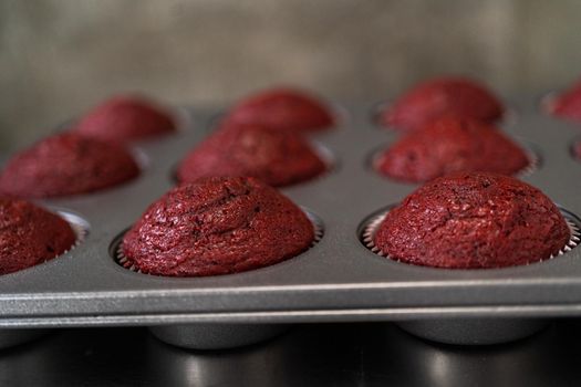 Cooling freshly baked red velvet cupcakes on a kitchen counter.