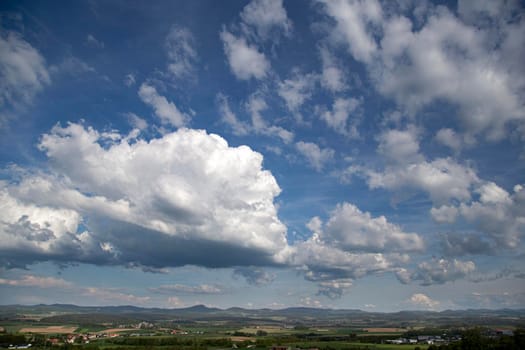 Beauty cloud against a blue sky background. Sky slouds. Blue sky with cloudy weather, nature cloud over the landskape. Over the land white clouds, blue sky and sun. High quality photo