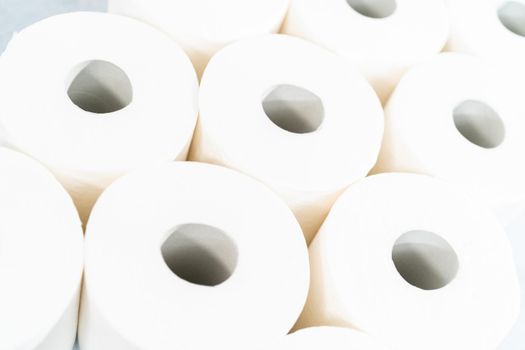 New white toilet paper rolls on a gray background.