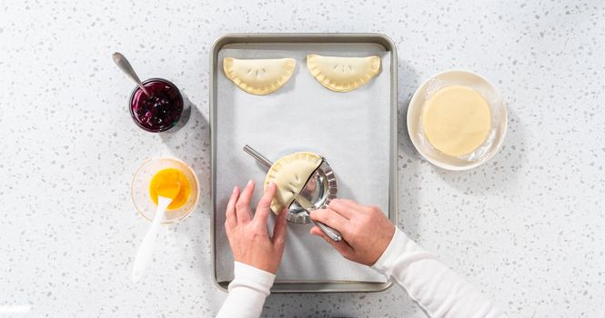 Flat lay. Filling empanada dough with blueberry pie filling to make sweet empanadas with blueberries.