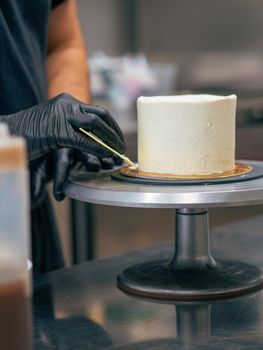 professional baker decorating a chocolate and cream cake with salty caramel