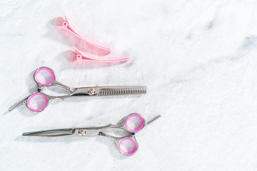 New barber pink scissors on a gray background.