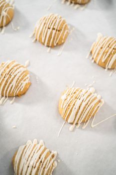 Drizzling melted white chocolate over freshly baked eggnog scones.