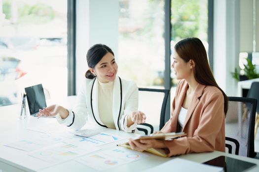 A portrait of a marketing employee and a salesperson using product documentation to plan sales.