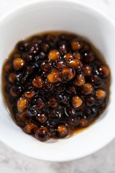 Freshly cooked boba pearls in a small white bowl.