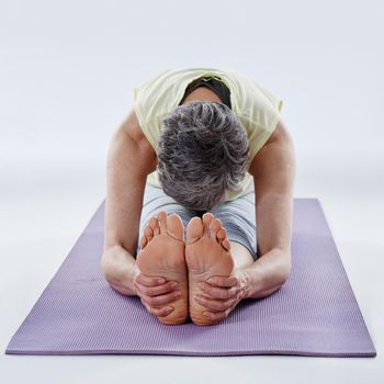 Pre-workout stretches. Full length shot of a woman stretching before yoga