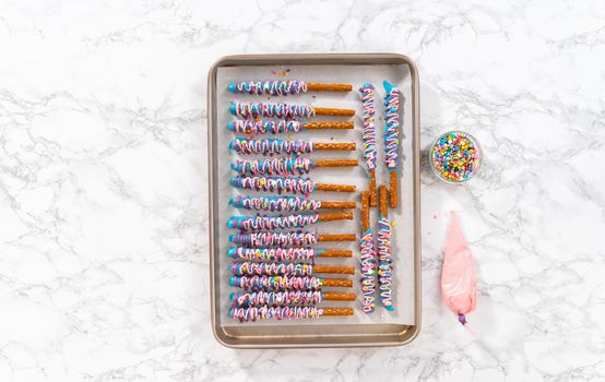 Mermaid chocolate pretzel rods drizzled with pink and purple chocolate and covered with sprinkles.