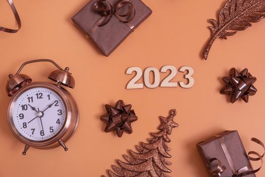 Flat lay 2023 new year numbers on color background with alarm clock, Christmas tree and gift boxes top view.