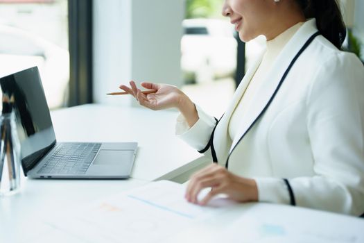 A portrait of a female employee using a computer video conferencing to discuss work through the Internet network.