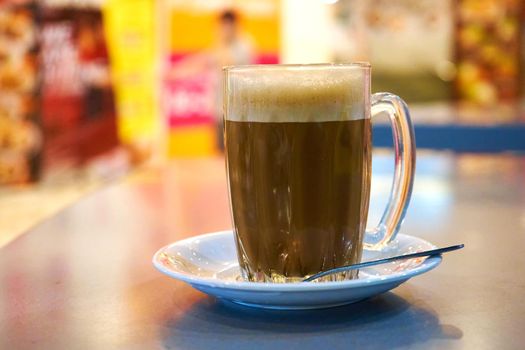 Glass cup with cocoa on a table in a cafe.