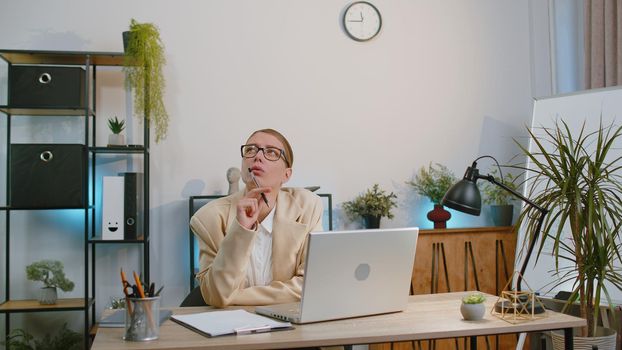 Businesswoman freelancer enters office workplace, working on laptop computer at desk. Professional manager freelancer woman works on notebook, sends messages makes online purchases watching movies