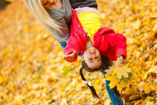 happy family mother and child daughter playing and laughing on autumn walk