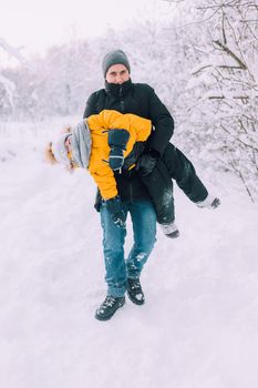 Dad turns the child in winter lifestyle . The Father-son relationship. Winter walks. Article about family