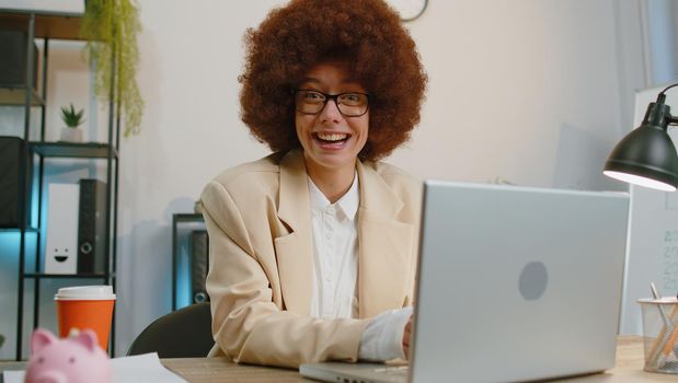 Concentrated businesswoman winner in suit working on laptop at home office desk typing browsing say Wow yes found out great lottery win good news celebrate. Female manager freelancer woman occupation