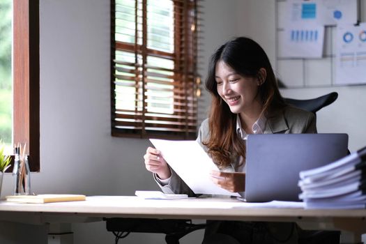 Asian businesswoman working in the office with working documents..