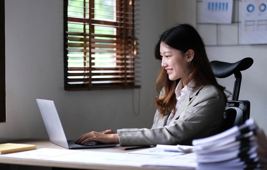 Portrait of smiling beautiful business asian woman working in office use computer with copy space. Business owner people sme freelance online marketing e-commerce telemarketing, work from home concept.