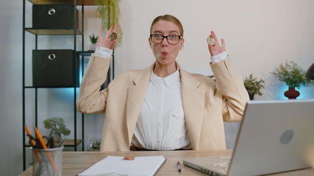 Businesswoman stock trader earning bitcoins after online monitoring trading operations. Increasing wealth financial prosperity. Professional freelancer woman working on laptop at office workplace desk