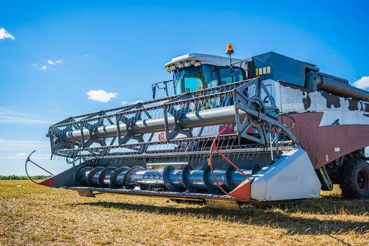 Agricultural machine for mowing wheat and other crops during the harvest. Combine harvester on a mowed wheat field