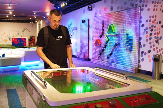 Dudes playing in air hockey on playground. Kuala Lumpur, Malaysia - 04.01.2020