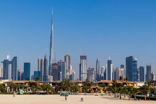 Dubai, UAE - 02.27.2021 Dubai public beach with city skyline on background.