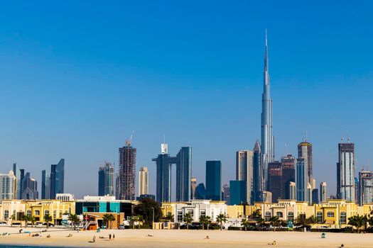 Dubai, UAE - 02.27.2021 Dubai public beach with city skyline on background.