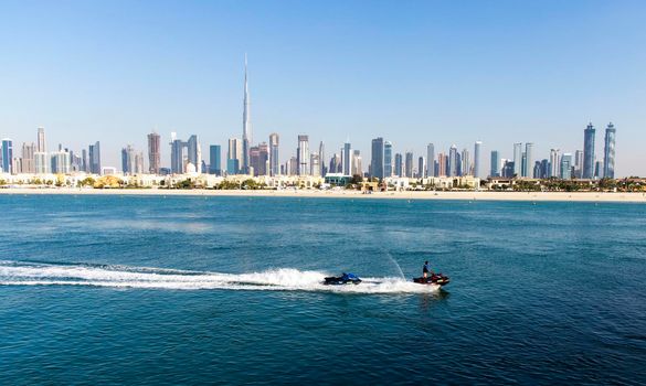 Dubai, UAE - 02.27.2021 Dubai public beach with city skyline on background.