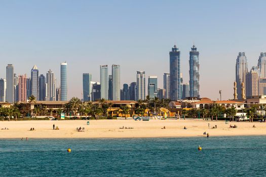 Dubai, UAE - 02.27.2021 Dubai public beach with city skyline on background.