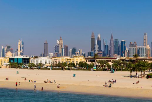 Dubai, UAE - 02.27.2021 Dubai public beach with city skyline on background.