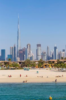 Dubai, UAE - 02.27.2021 Dubai public beach with city skyline on background.