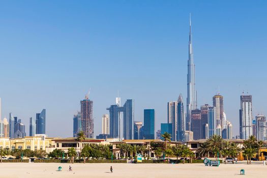 Dubai, UAE - 02.27.2021 Dubai public beach with city skyline on background.