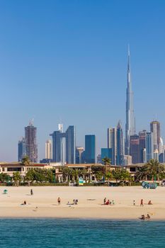 Dubai, UAE - 02.27.2021 Dubai public beach with city skyline on background.