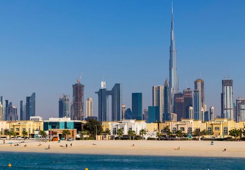 Dubai, UAE - 02.27.2021 Dubai public beach with city skyline on background.