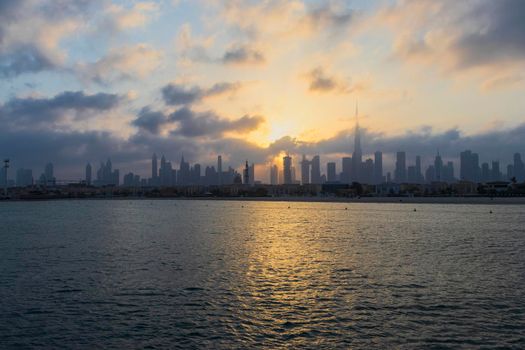 Dubai, UAE - 03.06.2021 Dubai public beach with city skyline on background.Sunrise hour