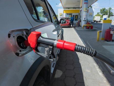 Silver car refuelling at the gas station, the concept of fuel energy, wide angle