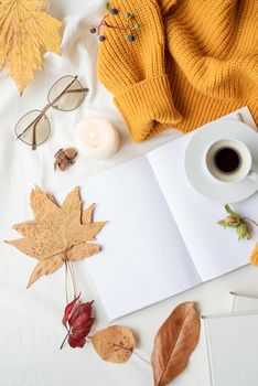 Back to school. Cozy autumn. Study and education concept. white blank book with autumn leaves and cup of hot tea on old table , mockup design