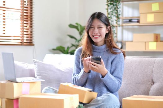 Portrait of Starting small businesses SME owners female entrepreneurs working on receipt box and check online orders to prepare to pack the boxes, sell to customers, sme business ideas online..