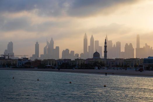 Dubai, UAE - 03.06.2021 Dubai public beach with city skyline on background.Sunrise hour