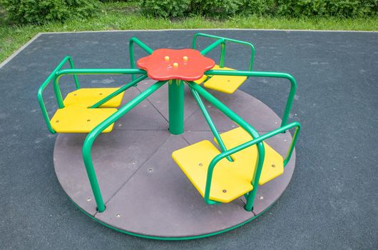 Multi-colored steel round carousel on the playground.