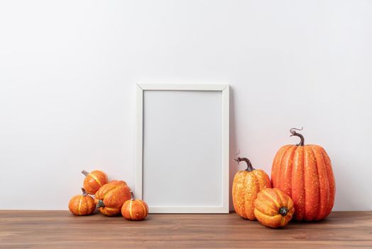 Photo frame and white pumpkins. Mockup Copy space for artwork. Autumn decor in interior.