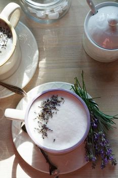 A cup of home made earl grey tea latte drink with lavender flower buds in white cups with fresh lavanda flowers on white table, good morning concept, selective focus., flat lay.