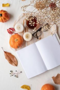 Back to school. Cozy autumn. Study and education concept. white blank book with autumn leaves and cup of hot tea on old table , mockup design, focus of foreground, selective focus