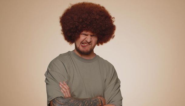 Dissatisfied man shaking head no, asking reason of failure, expressing disbelief irritation, feeling bored, disappointed in result, bad news. Adult guy isolated alone on beige studio wall background