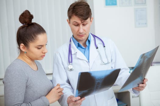 Young woman discussing her x-ray scans with the doctor at the hospital