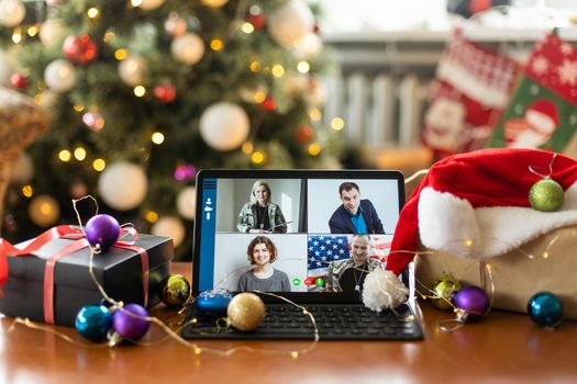 Family video call with kid presenting gift by remote chat digital tablet screen on Merry Christmas table holiday background. Xmas online virtual family party celebration, Happy New Year videocall.