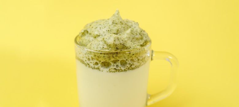 Dalgona Matcha Latte, yellow background. Matcha green tea. Selective focus. Copy space