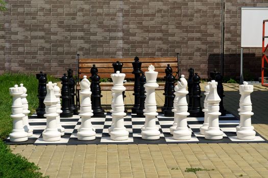 Giant garden chess set set out for a game of chess giant chess board. Selective focus